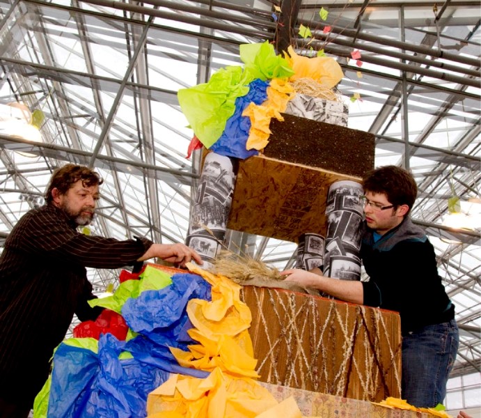 Designer Cory Christopher gets a helping from his father Ron Cherdarchuk working on the final preparations for the 15-foot-tall cake designed for the 150th gala being held at 