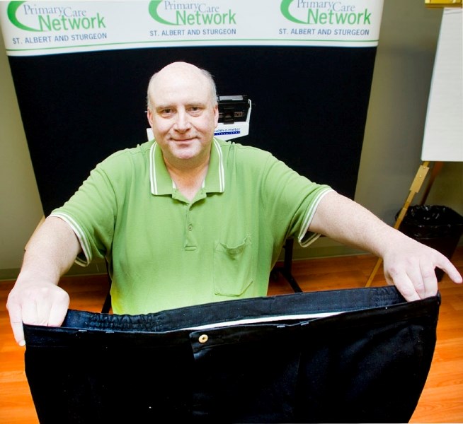 Jim Starko holds up a pair of his old pants he no longer fits into after losing 110 pounds with the help of the Weight Wise program at the St. Albert and Sturgeon Primary