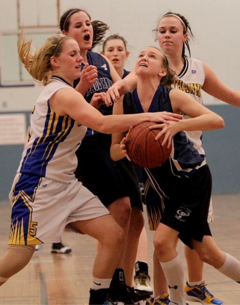 Katie Burak (left) and Zoe Downing of the St. Albert Skyhawks have Josee Larson covered like a blanket in Saturday&#8217;s final at the 21st annual Optimist Showdown in St.