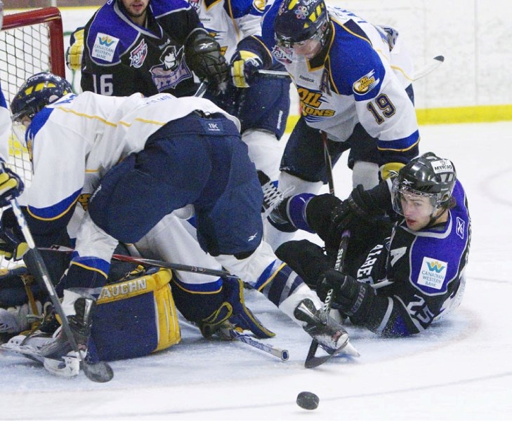 Derek Bacon (25) of the St. Albert Steel watches the puck slip away from a pile-up of players in Friday&#8217;s 3-2 win over the Fort McMurray Oil Barons at Performance
