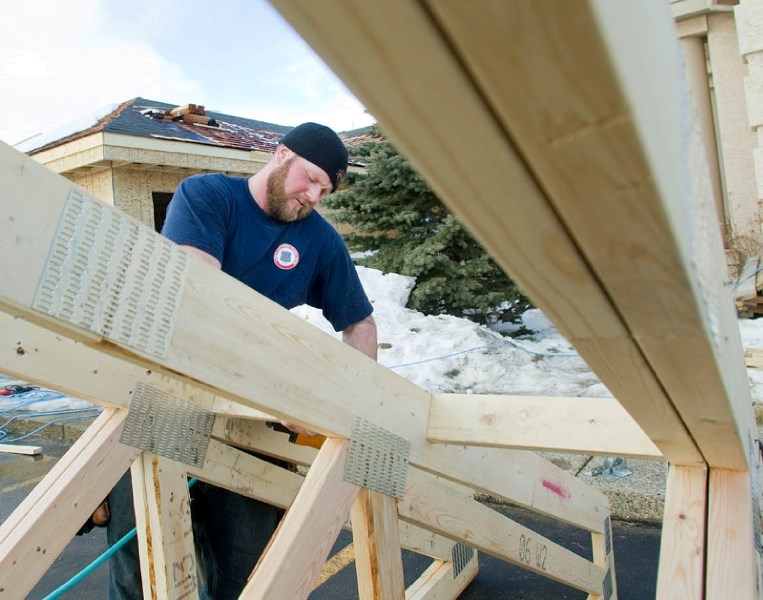 Brad Chamberlain hammers parts of a rooftop that will part of a new gym extension of the Red Willow Community Church along Corriveau Avenue last Friday afternoon.