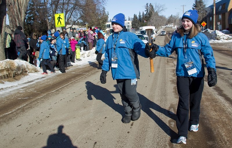 Josh Hinkle and Dana Koroluk start the second leg of the ATCO Gas Torch Relay through the streets of St. Albert for the Alberta 55 Plus Winter Games on a chilly Thursday