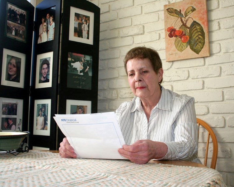 Local senior Evelyn Ferguson sorts through some unpleasant financial information at her Grandin home. Ferguson is considering moving away from St. Albert because she can no