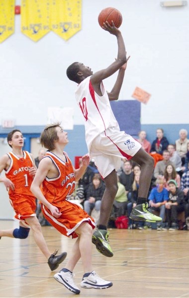 Aymar Sigue of the Vincent J. Maloney Marauders leaps for a shot in front of Josh Dobbins (1) and Carter McKinley of the Lorne Akins Gators in the SAPEC tier 1 basketball