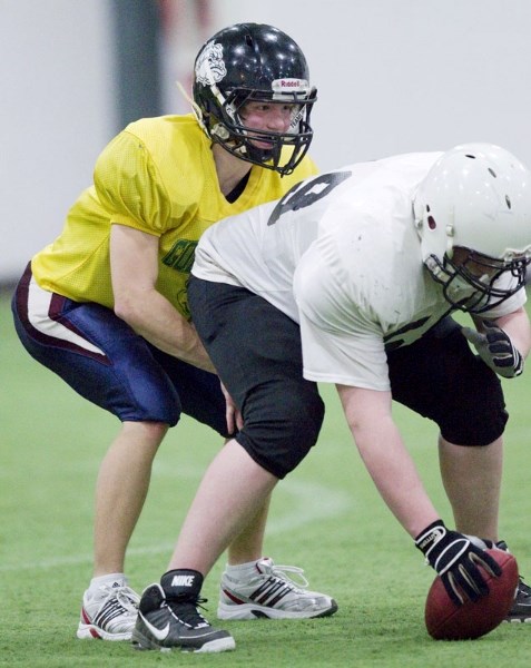 Dallas Moroz works the snap count behind centre Zach Piercey for the St. Albert Storm at Wednesday&#8217;s practice at the Karl Weidle Indoor Centre. The midget spring league 