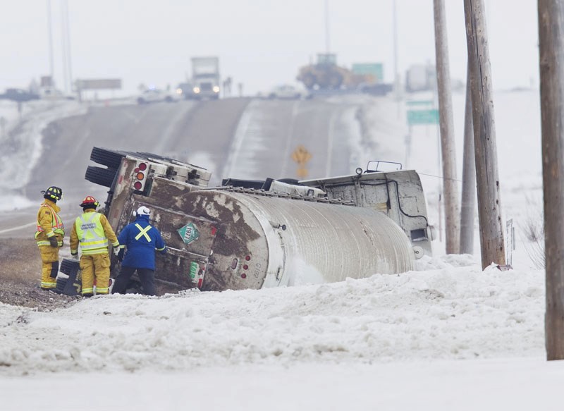 Firefighters inspect the back of a semi-truck carrying liquid nitrogen lying on its side in the ditch along Highway 37 just east of Highway 2. Part of Highway 37 was shut