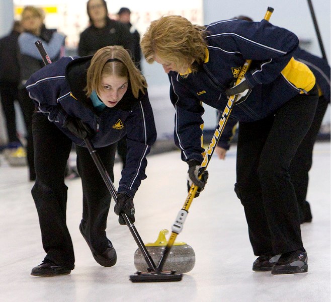 Lauren Jenkyns (left) and Laurie Schreiner sweep a rock for the Kathy Piper rink in Sunday&#8217;s A-B final against Cathy Lane in the President&#8217;s Cup playoffs at the