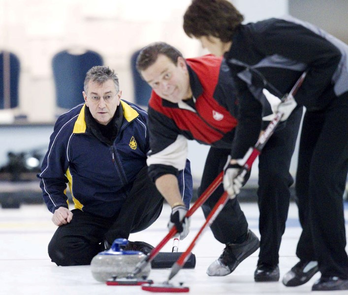 Dan Magotiaux and Sandy Sadoway sweep Wilf Gunderson&#8217;s delivery in the President&#8217;s Cup final Sunday at the St. Albert Curling Club. The Gunderson rink