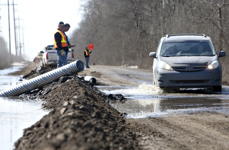 Sturgeon County transportation workers prepare to install a culvert to address flooding issues at Range Road 251 near Poundmaker Road on Tuesday.