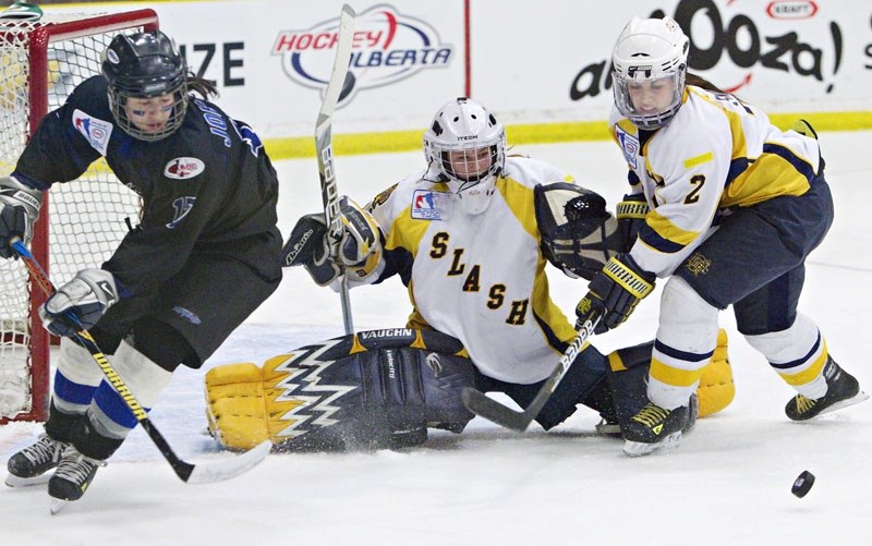 St. Albert Slash goalie Emily Mitchell and defenceman Eliza Snider guard the net as Rachel Johnson of the Edmonton Thunder eyes up the puck in Tuesday&#8217;s Esso Cup tilt