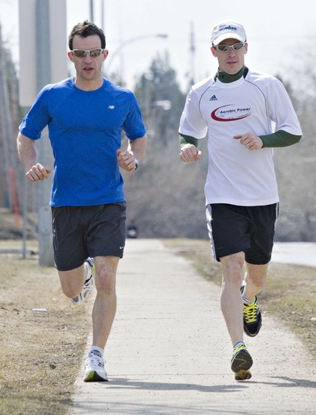 Paul Kane High School teachers Josh Machney (L) and Marc Meunier run along Sir Winston Churchill Avenue on Tuesday afternoon in preparation for the RunWild Leading Edge