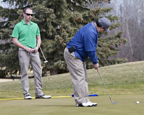 Brett Mugford watches Bill Lee make his putt during Sunday&#8217;s round by the Edmonton residents at the Sandpiper Golf &amp;amp; Country Club. The 18-hole course opened