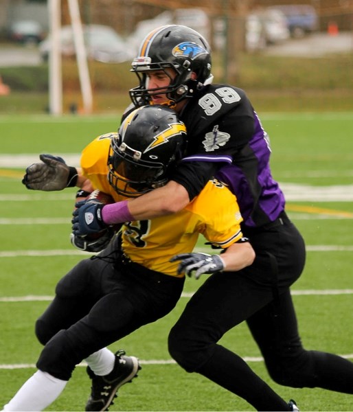 Adam Sturgess of the St. Albert Storm wraps up the Edmonton Chargers&#8217; ball carrier Saturday at Clarke Park in the last tier I/II division match before the playoffs in