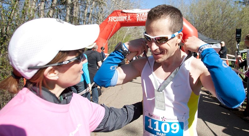 Marc Meunier of St. Albert is greeted at the finish line by volunteer Deb Scaber after winning the first annual RunWild Leading Edge Marathon on Sunday morning. The Paul Kane 