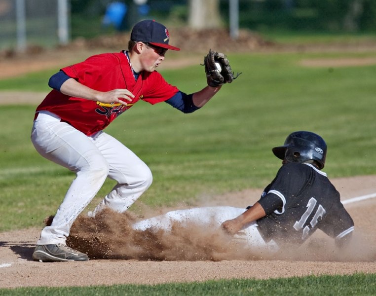 A SEEBA player tries to beat the tag by Aaron Larose of the St. Albert Cardinals while sliding into third base in Tuesday&#8217;s bantam AAA game at Legion Memorial Park. The 