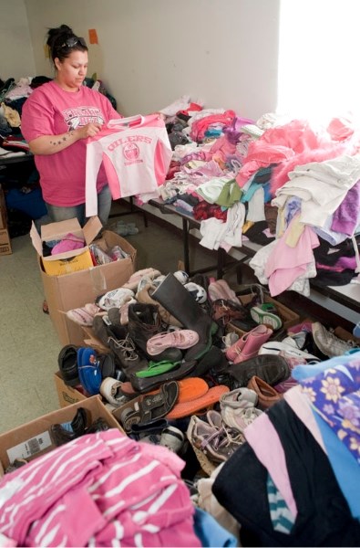 Alexander resident Sharice Cardinal sorts through the piles of donated clothes that have poured into the Alexander community hall this week in response to the recent fire in