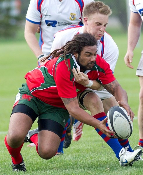 A player with the St. Albert men&#8217;s second division tries to pin down both his Druids&#8217; opponent and the ball during Friday night&#8217;s match-up at Ellerslie
