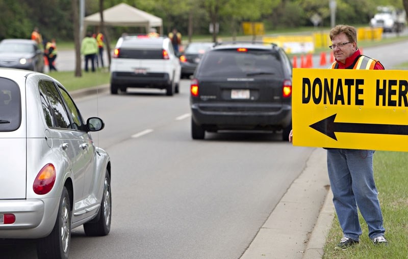 Saint City Rotary treasurer Bart Paterson collects donations for the annual Mile of Money campaign on June 4 along Boudreau Road. Motorists passed over $5