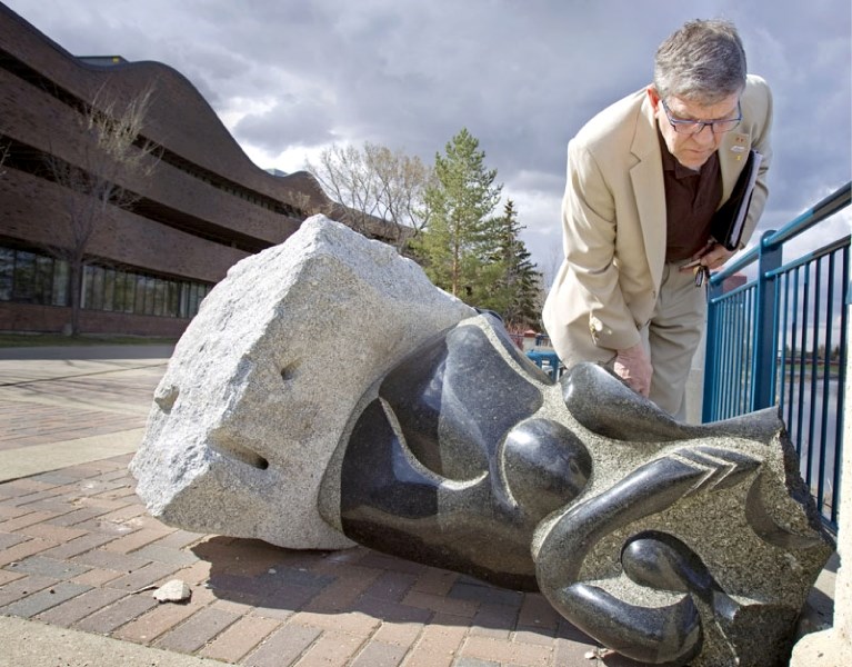Mayor Nolan Crouse inspects damage to the sculpture StarWoman