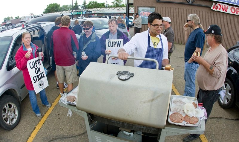 Striking Canada Post workers have a barbecue at the Hebert Road distribution facility on Friday during the lunch hour. Postal workers