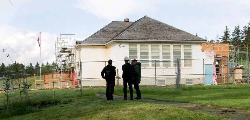 Construction workers working on the restoration of the Little White School take a break to discuss the project. The final work should be finished by July 24.