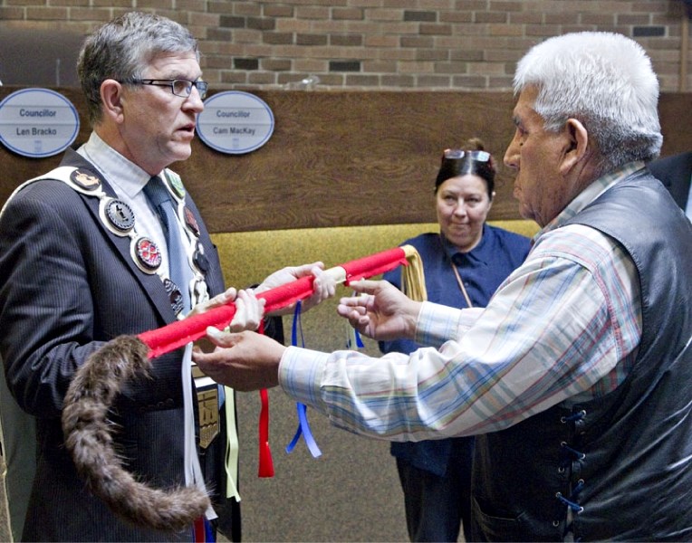 Alexander elder Tony Arcand presents a ceremonial staff to St. Albert Mayor Nolan Crouse in the city&#8217;s council chambers on Monday as part of National Aboriginal Day