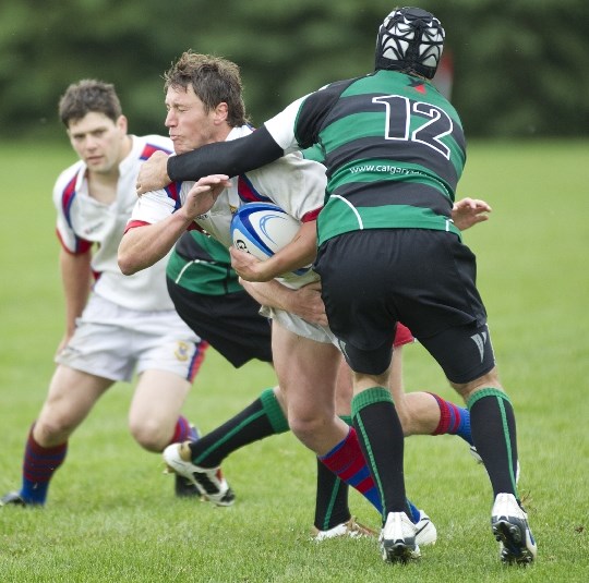 Jake Robinson of St. Albert is corralled by the Calgary Saracens in premier men&#8217;s action Saturday. The 2010 provincial champions scored 12 tries and added five