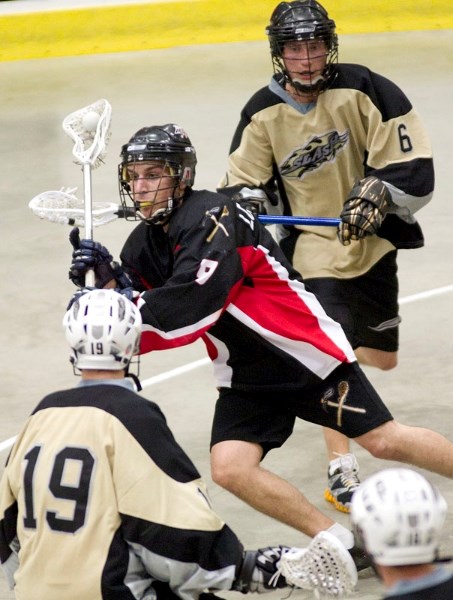 Shane Lopatynski of the St. Albert Miners passes the ball through Spruce Grove Slash players Phaelan Sarchuk (front) and Ryan Polny during a game at Servus Place Wednesday.