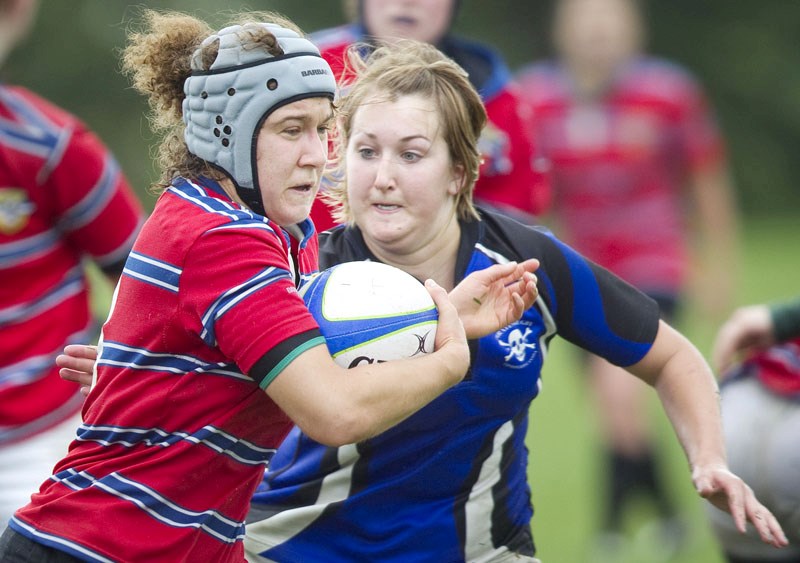 Winger Marcia Davis of the St. Albert senior ladies&#8217; squad gets yanked to the ground by a pair of Pirates defenders during the club&#8217;s 10-7 loss at home on