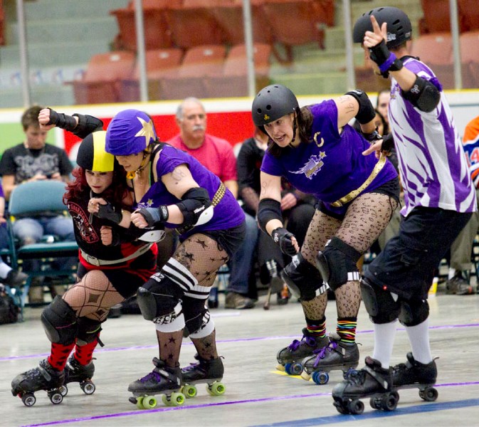 St. Albert Heavenly Rollers players Maddie Rage (centre) and co-captain Petra Phi make their way past one of the Saskatoon Killa Bees players during a match at Servus Credit