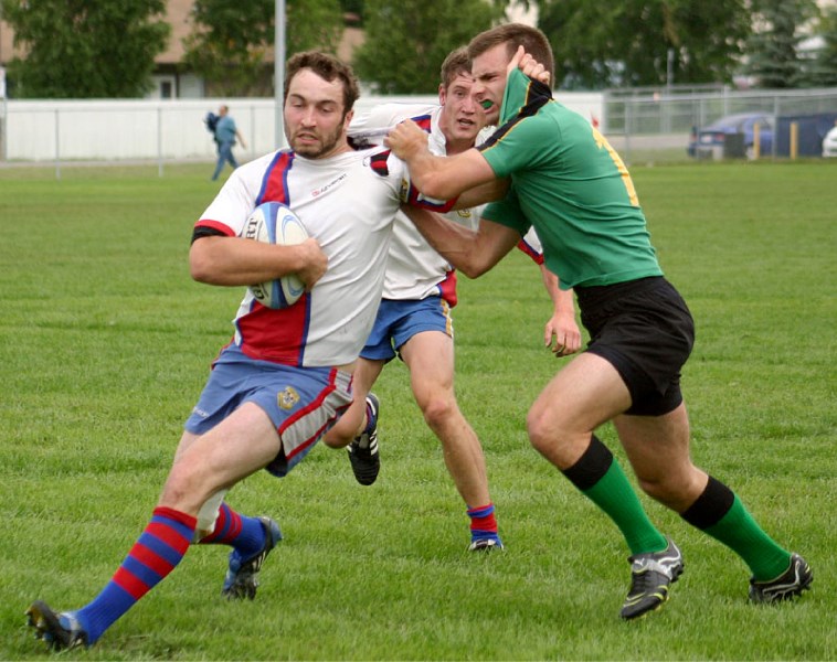 SARFC premiers&#8217; eight-man Brett Kelly does his best to fend off a Lep-Tigers defender as the two sides clashed Saturday afternoon at Leading Edge Field. St. Albert