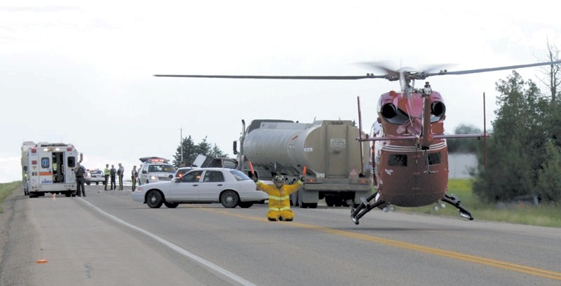 A member of the Sturgeon County Fire Department helps to land the STARS air ambulance after a three-vehicle collision on Highway 44 just south of the Westlock County line