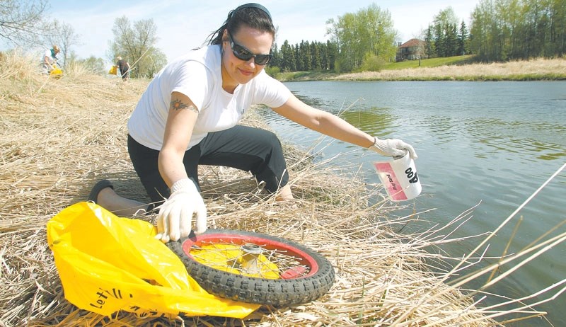Eve Sarraino helps clean up along the Sturgeon River&#8217;s edge as a part of a cleanup project in May 2010. This year