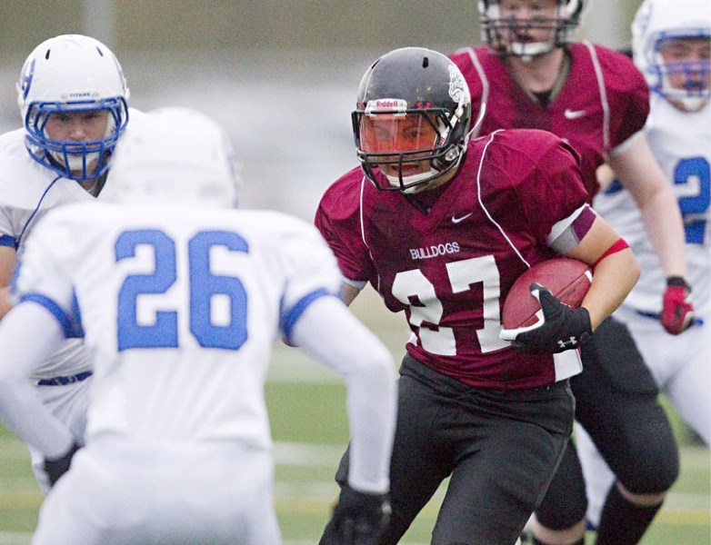 Austin Braithwaite of the Bellerose Bulldogs makes tracks with the ball in Thursday&#8217;s exhibition against the Harry Ainlay Titans at the Riel Park turf field. The Titans 