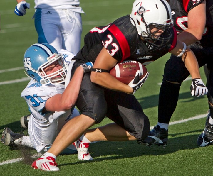 Paul Kane Blues defender Josh Hauptman hangs on to bring a Salisbury Sabres ball carrier down in high school Carr conference football action at Clarke Park on Thursday