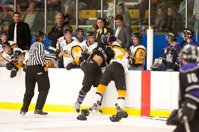 Jordan Abt of the St. Albert Steel and Spencer Dorowicz of the Olds Grizzlys grapple in front of the Olds bench during a second-period scrap Friday. Abt scored once in the