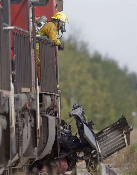 A Sturgeon County Fire and Rescue member surveys the scene of a train and semi truck collision near Villeneuve around 3 p.m. on Sunday. Emergency crews had to deal with fire