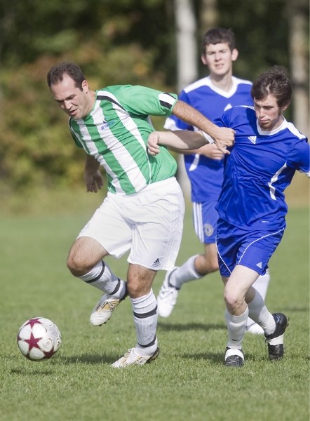 Dobry Mihov of SA United fends off Dylan Bergunder with CSKA Blues FC in the St. Albert Men&#8217;s Soccer League playoff cup final Sunday at Riel Park. In the background is