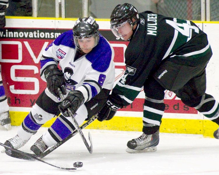 John Baird of the St. Albert Steel and Blair Mulder of the Sherwood Park Crusaders compete for the puck during second period action in Friday&#8217;s home opener at