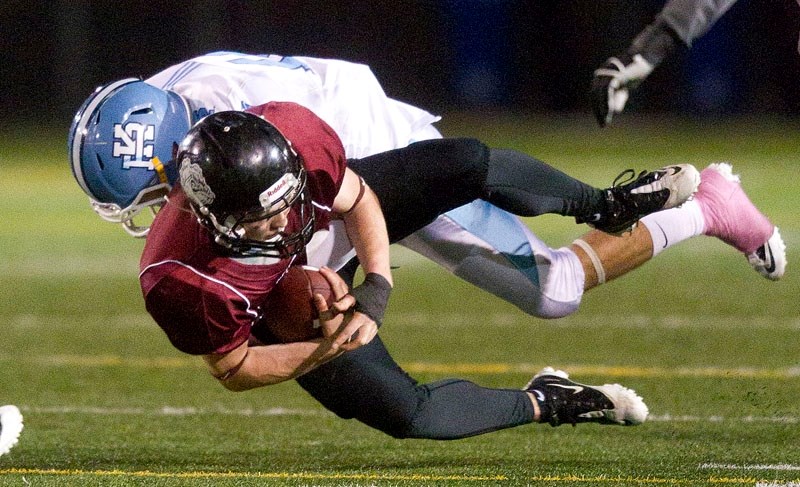 Ben Graunke of the Bellerose Bulldogs is tackled by Mackenzie Enger of the Paul Kane Blues after Graunke intercepted a pass at midfield on the second-last play in the first