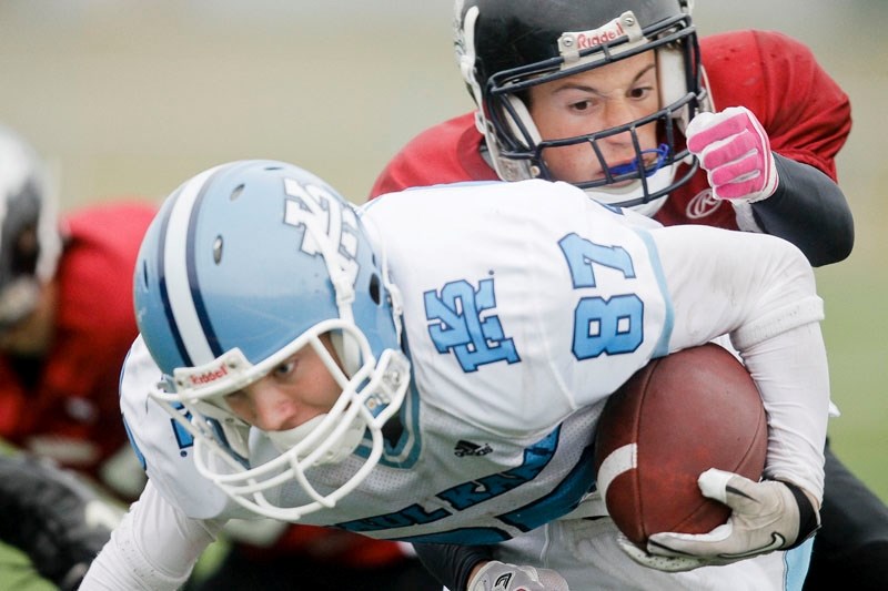 Tyler Turner of the Paul Kane Blues is tracked down from behind by Dean Ciampanelli of the Bellerose Dawgs in high school junior football action Tuesday. The Blues beat the