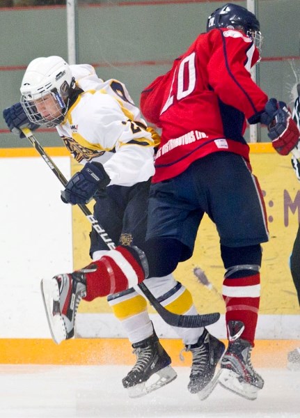 Taylor Fontaine of the St. Albert Raiders and Tyler Palmer of the CAC Gregg Distributors bang along the boards for the puck during Sunday&#8217;s midget AAA game at Bill