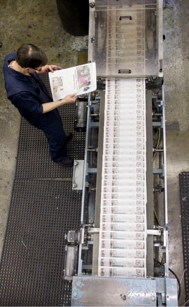 Press crew member Jeff Ferster reviews a freshly-printed paper. The Gazette circulates 21