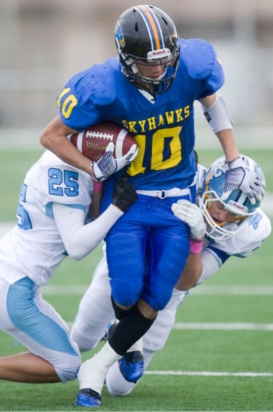 A pair of Paul Kane tacklers try to slow down Danton Tait-Vanderheide of the St. Albert High Skyhawks in Thursday&#8217;s football game at the Riel Park turf field. The