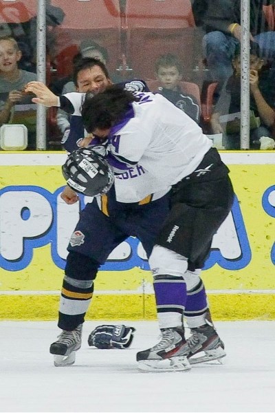 Suede Omeasoo of the Calgary Mustangs knocks the helmet off Landan Viveiros of the St. Albert Steel during their second-period scrap Saturday at Performance Arena. The