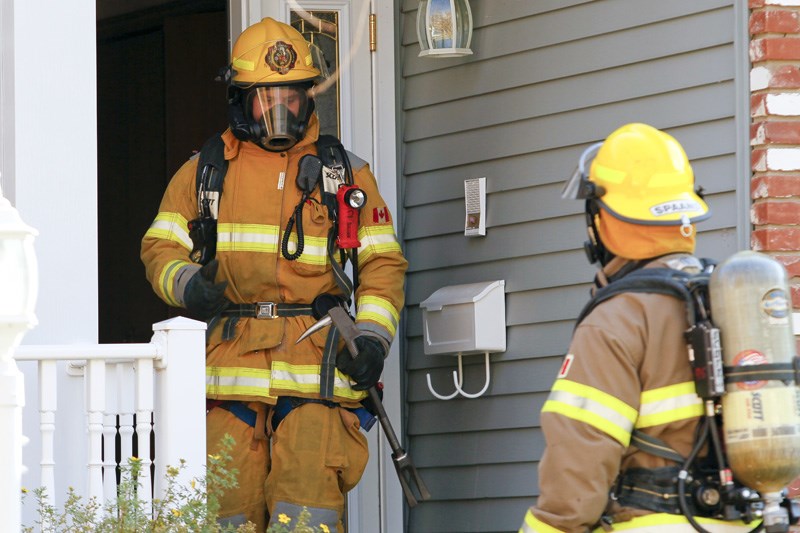 Members from St. Albert Fire Services check out a residential structure fire on Pineridge Crescent on Friday afternoon.