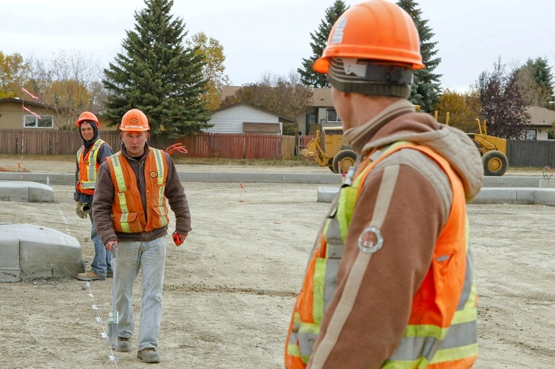 A work crew is busy readying for road paving at the site of Aurora Place