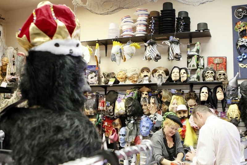 A wall of masks looks down as Karrie Verhulst