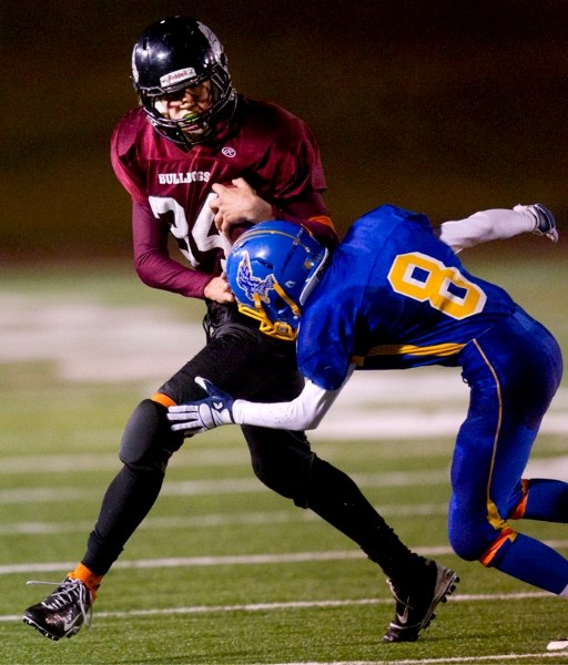 Nick Svenson of the Bellerose Dawgs fights off a tackler against the Bev Facey Falcons in Wednesday&#8217;s metro Edmonton high school junior semifinal Wednesday. Despite a
