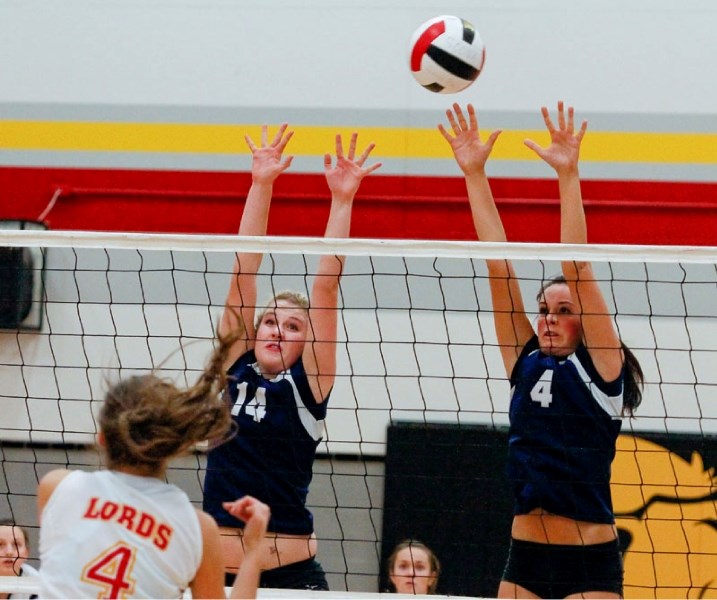 Emma Cunningham (left) and Maddi Agius of the Paul Kane Blues attempt to block a spike against the Scona Lords in Wednesday&#8217;s Edmonton zone ranking game for provincial